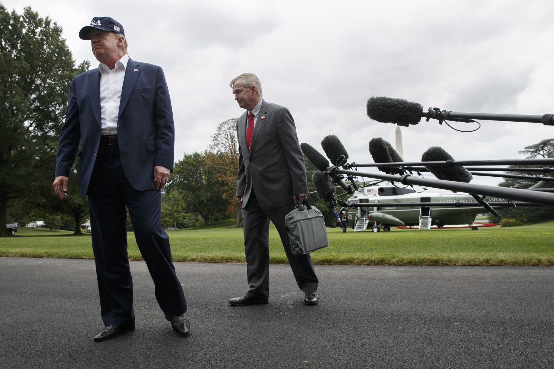 President Donald Trump and Coast Guard Rear Admiral Peter Brown turn away from the microphones after speaking to the media on return to the White House from Camp David, Sunday, Sept. 1, 2019, in Washington. 