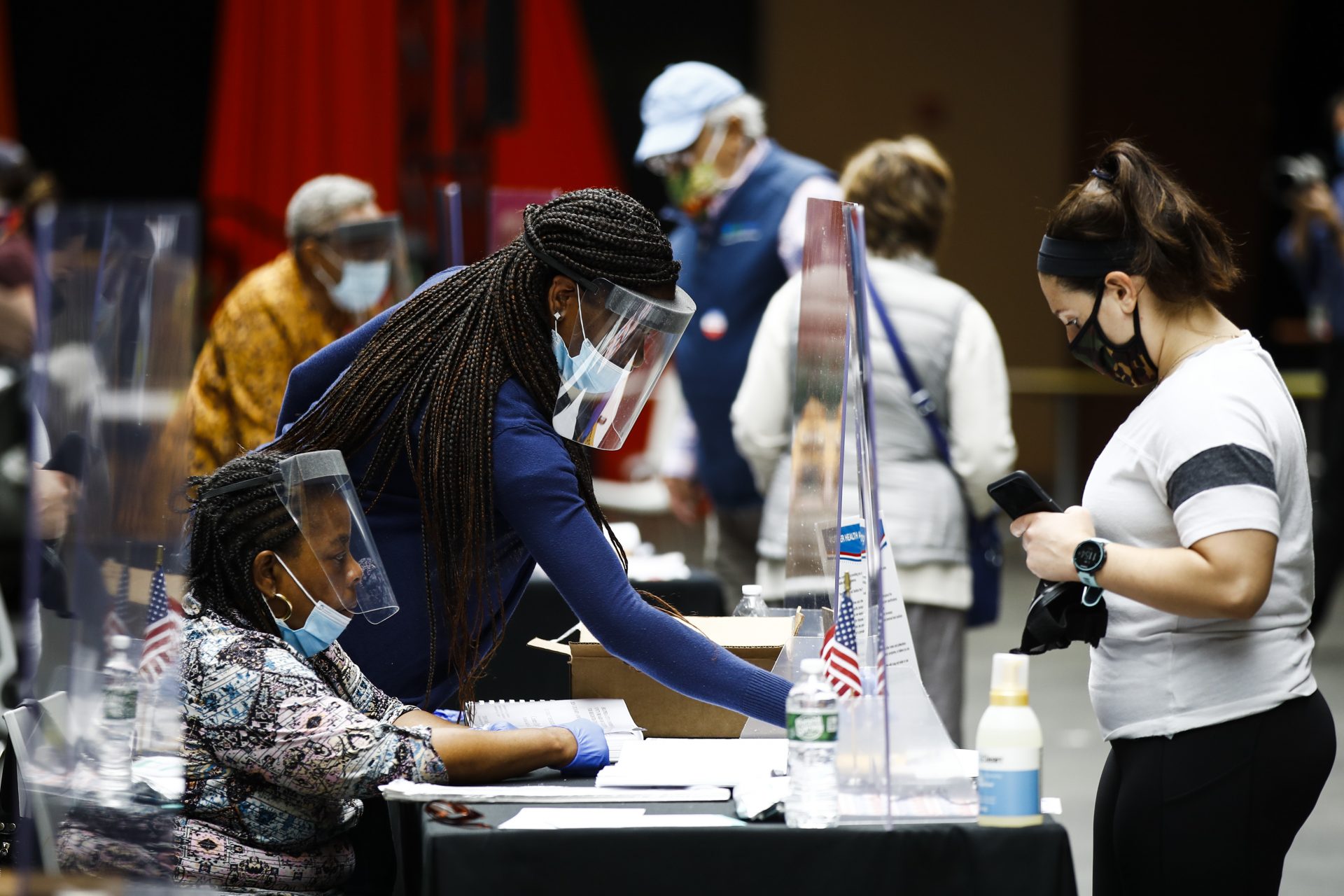 Election workers, left, check in voters before they cast their ballots in the Pennsylvania primary in Philadelphia, Tuesday, June 2, 2020.