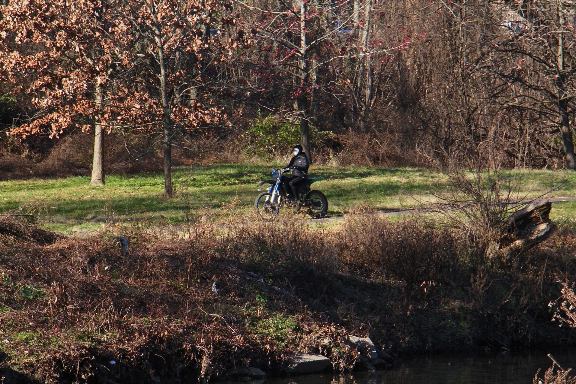 An off-roader rides his dirt bike on the trails at Tacony Creek Park.