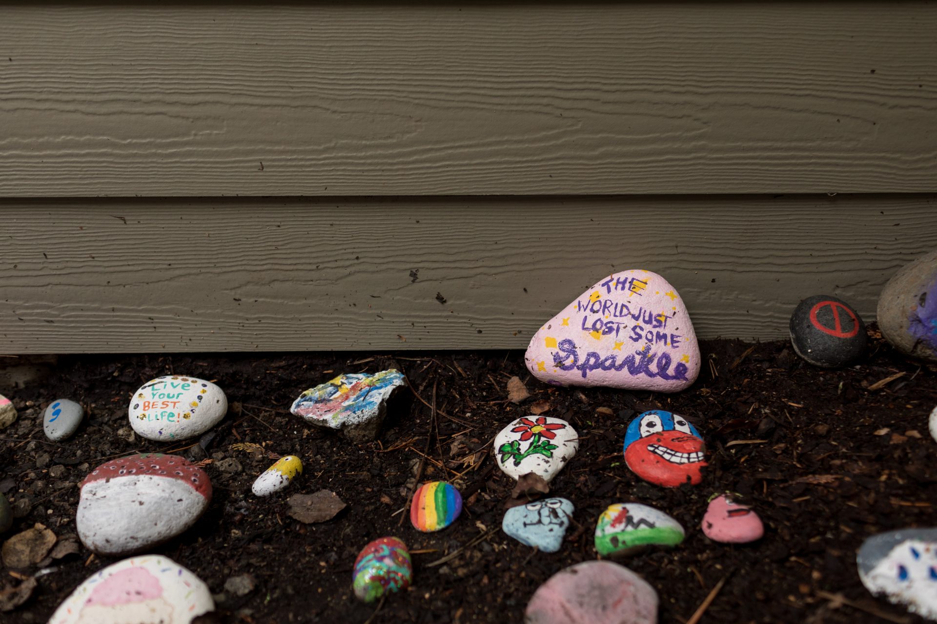 Painted rocks sit outside Sarah McSweeney's group home in Oregon City, Ore., on Nov. 24, 2020. McSweeney's housemates painted a rock to read "The World Just Lost Some Sparkle" in pink and purple after McSweeney's death.