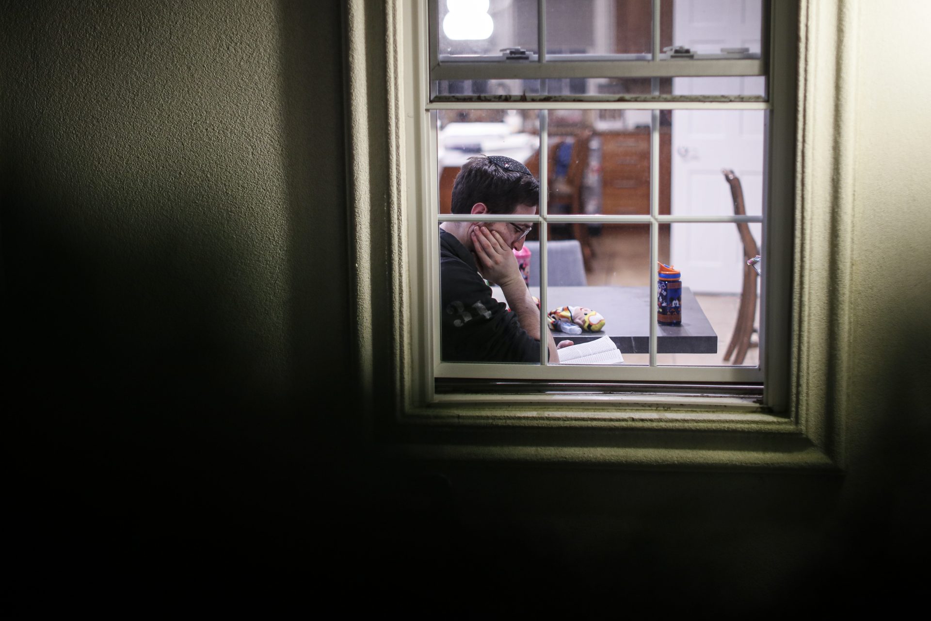 FILE PHOTO: A self-quarantined resident who says he tested positive for COVID-19 listens beside his window as volunteers perform a Purim reading from the Book of Esther, Monday, March 9, 2020, in New Rochelle, N.Y.