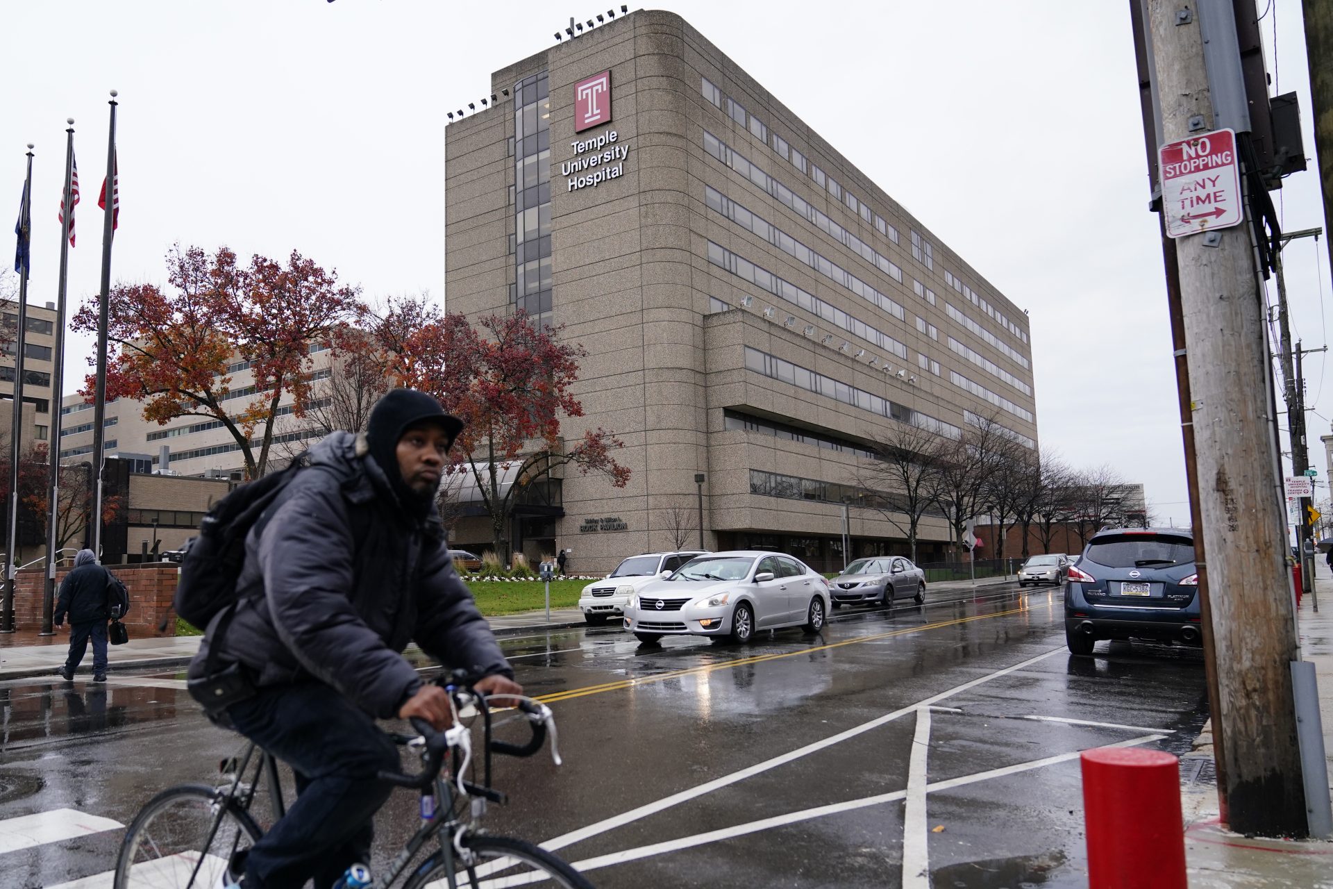 A man rides a bicycle past Temple University Hospital, Friday, Dec. 4, 2020, in Philadelphia. Hospital beds are filling up and medical staffs are being stretched to the limit as Pennsylvania's health care system copes with a growing number of seriously ill COVID-19 patients.