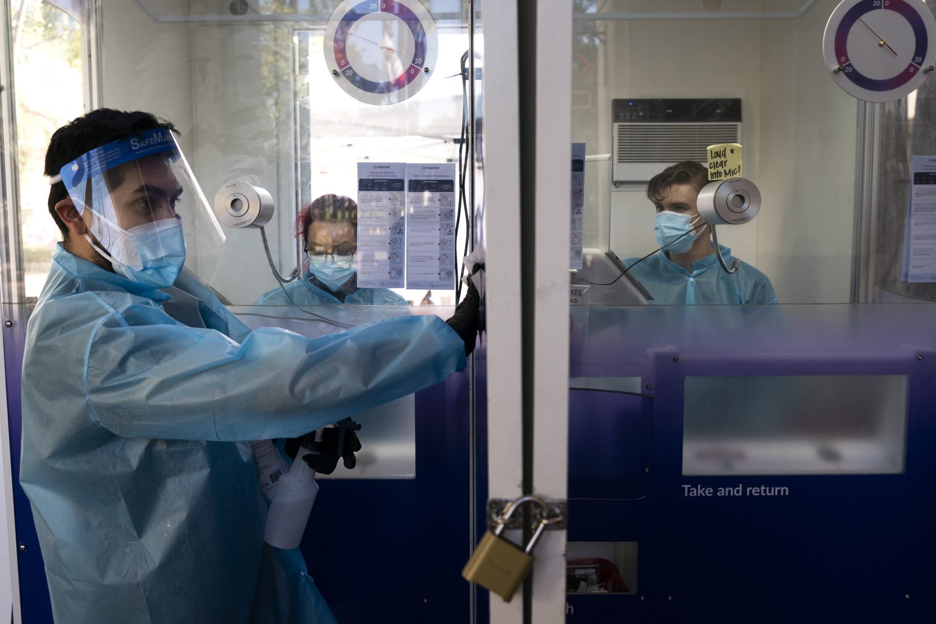FILE PHOTO: In this Dec. 9, 2020, file photo, test specialist Elijah Sanchez disinfects a testing booth at a COVID-19 testing site in Los Angeles.