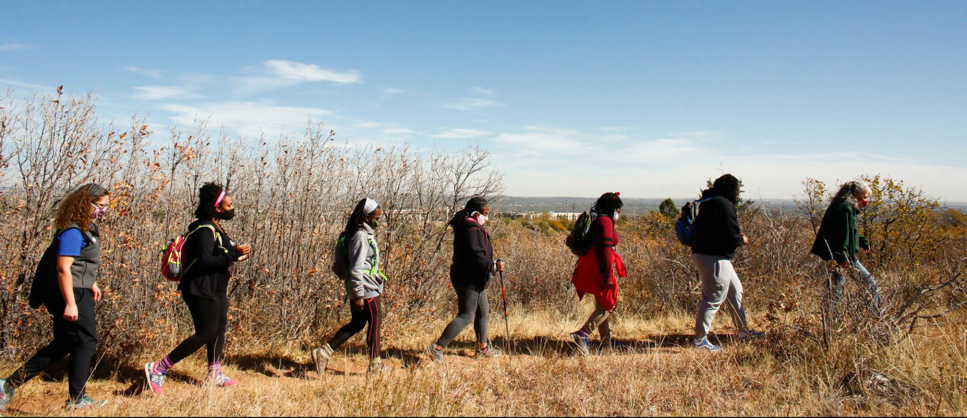 Left to right: Theresa Odello, Jessica Newton, Jan Garduno, Ashanta Cyprian, Joy Eloi and Jewyl Newton follow park volunteer Lynn Wilson during a hike through Bear Creek Regional Park in Colorado Springs, Colorado, on Oct. 24, 2020.