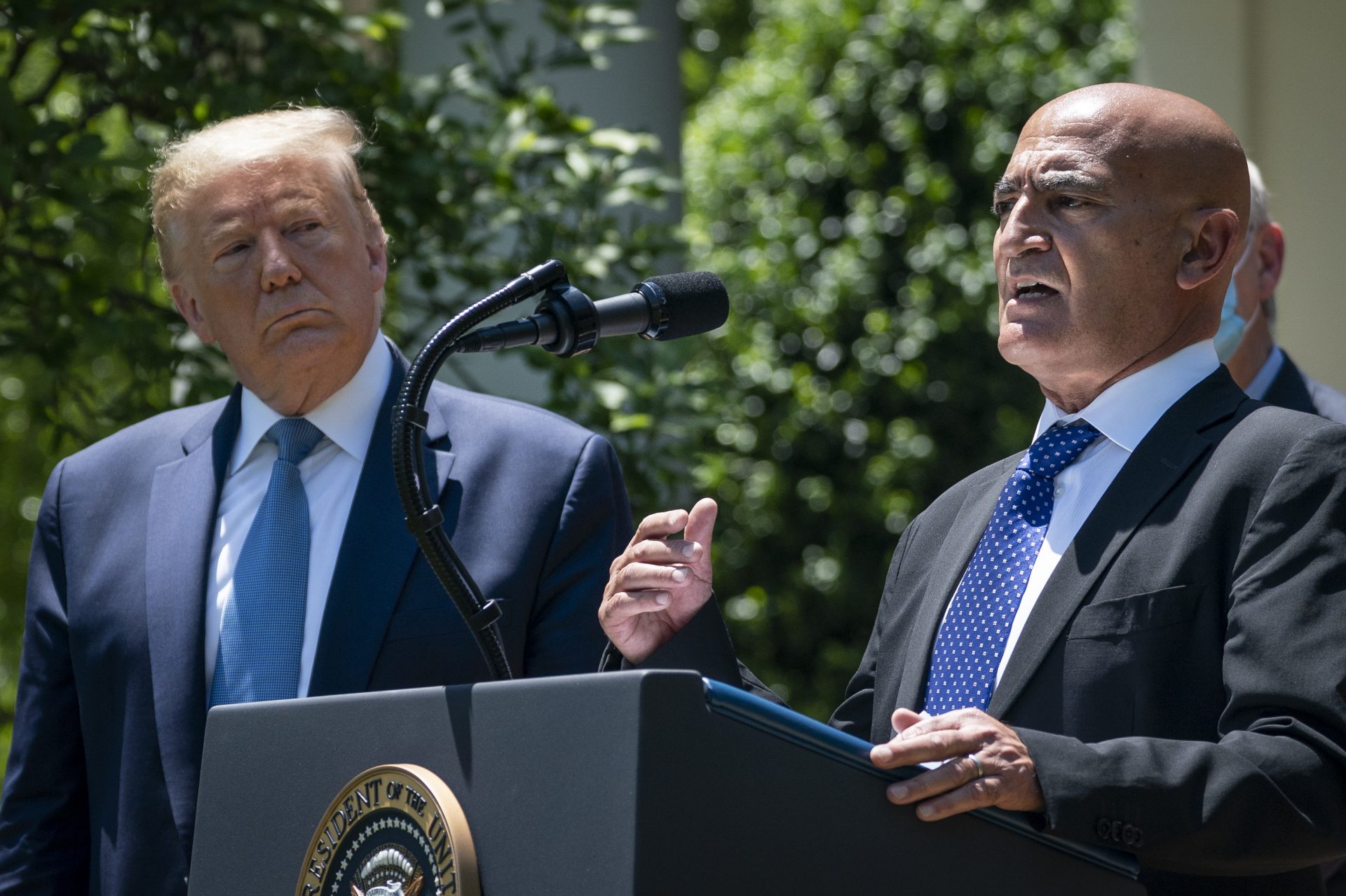 President Trump listens as Moncef Slaoui, the former head of GlaxoSmithKlines vaccines division, speaks about coronavirus vaccine development on May 15.