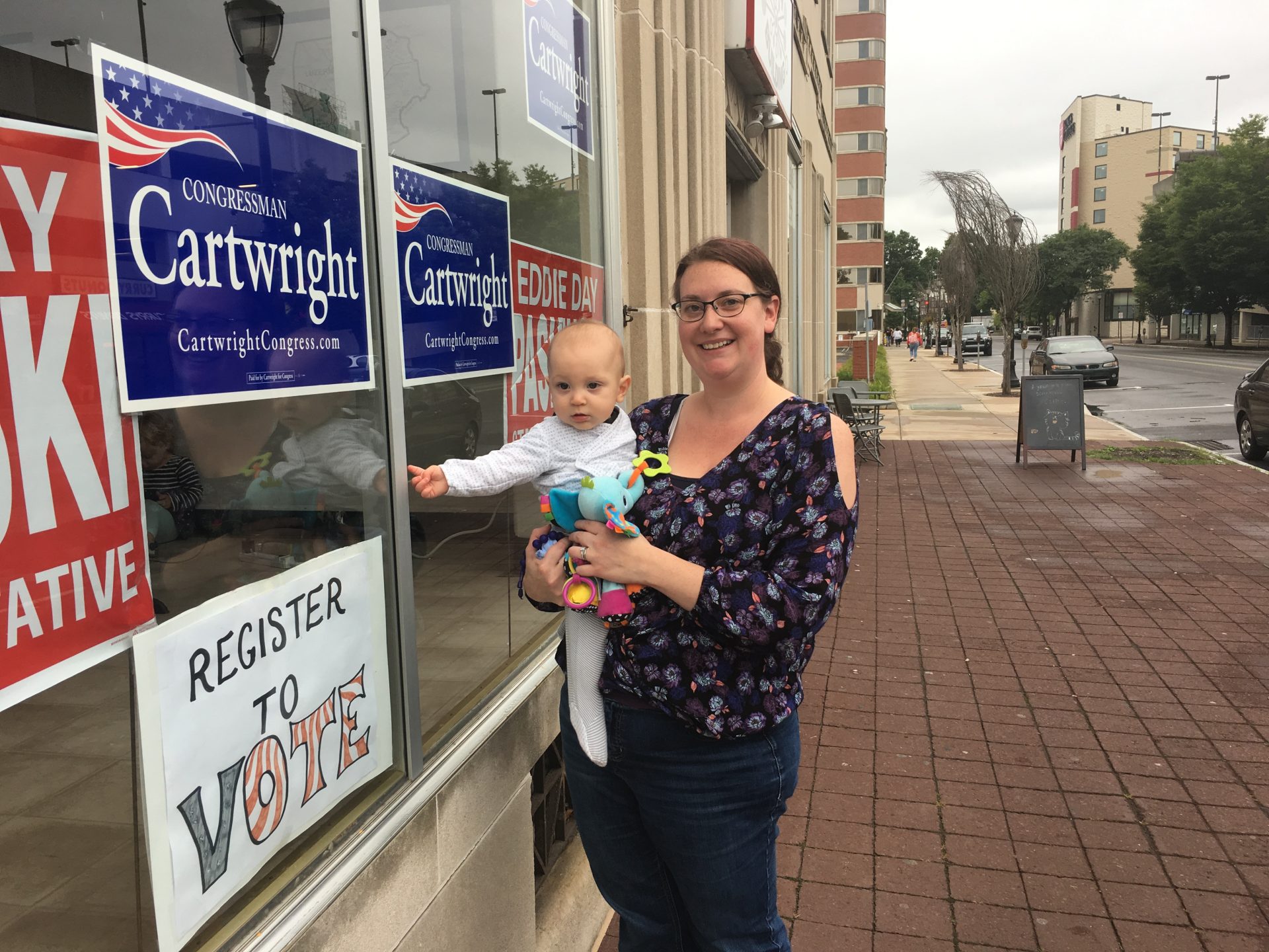 Democrat Alisha Hoffman-Mirilovich stands outside a campaign office in Wilkes-Barre on Sept. 12, 2018, while holding her son.