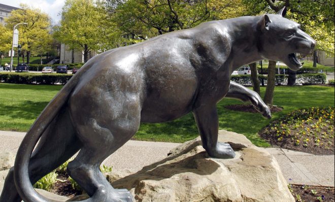 A statue representing the "Pitt Panther" mascot of the University of Pittsburgh is seen across the street from the iconic Cathedral of Learning on the University of Pittsburgh campus.