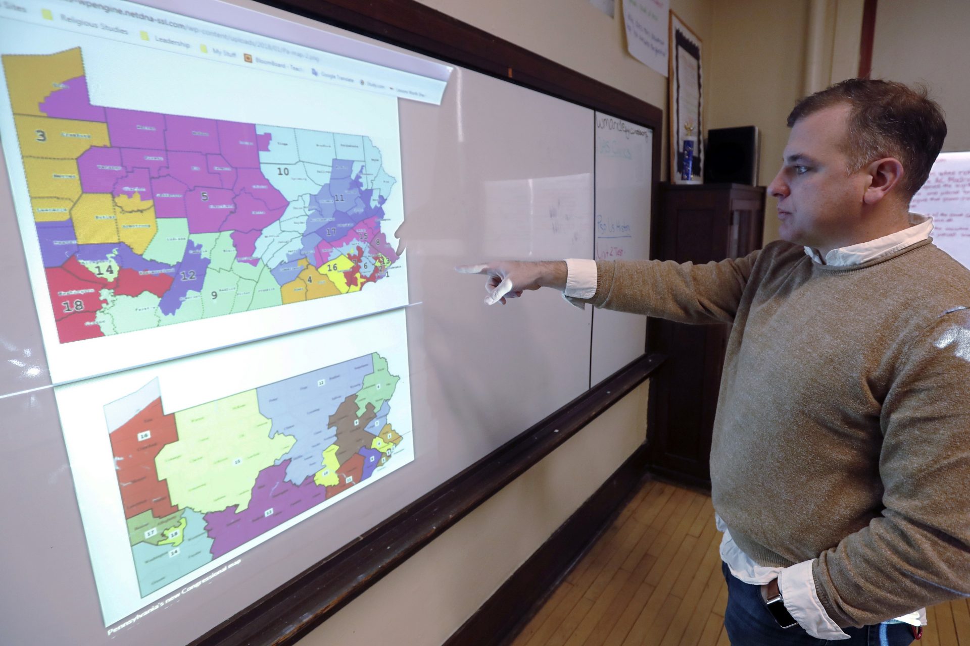 FILE PHOTO: William Marx, points to projected images of the old congressional districts of Pennsylvania on top, and the new re-drawn districts on the bottom, while standing in the classroom where he teaches civics in Pittsburgh on Friday, Nov. 16, 2018.