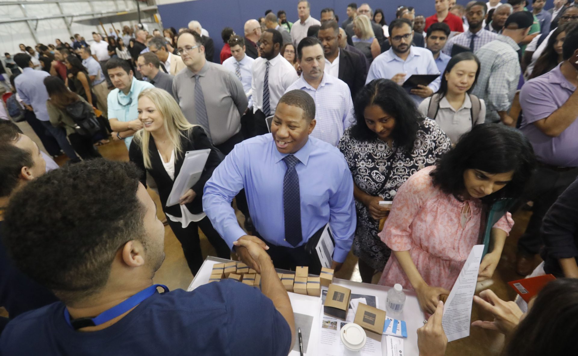 In this Sept. 17, 2019, photo job seeker Cedric Edwards, center, shakes hands with recruiter Allen Lewis, left, during an Amazon job fair in Dallas. On Wednesday, Oct. 2, payroll processor ADP reports how many jobs private employers added in September.
