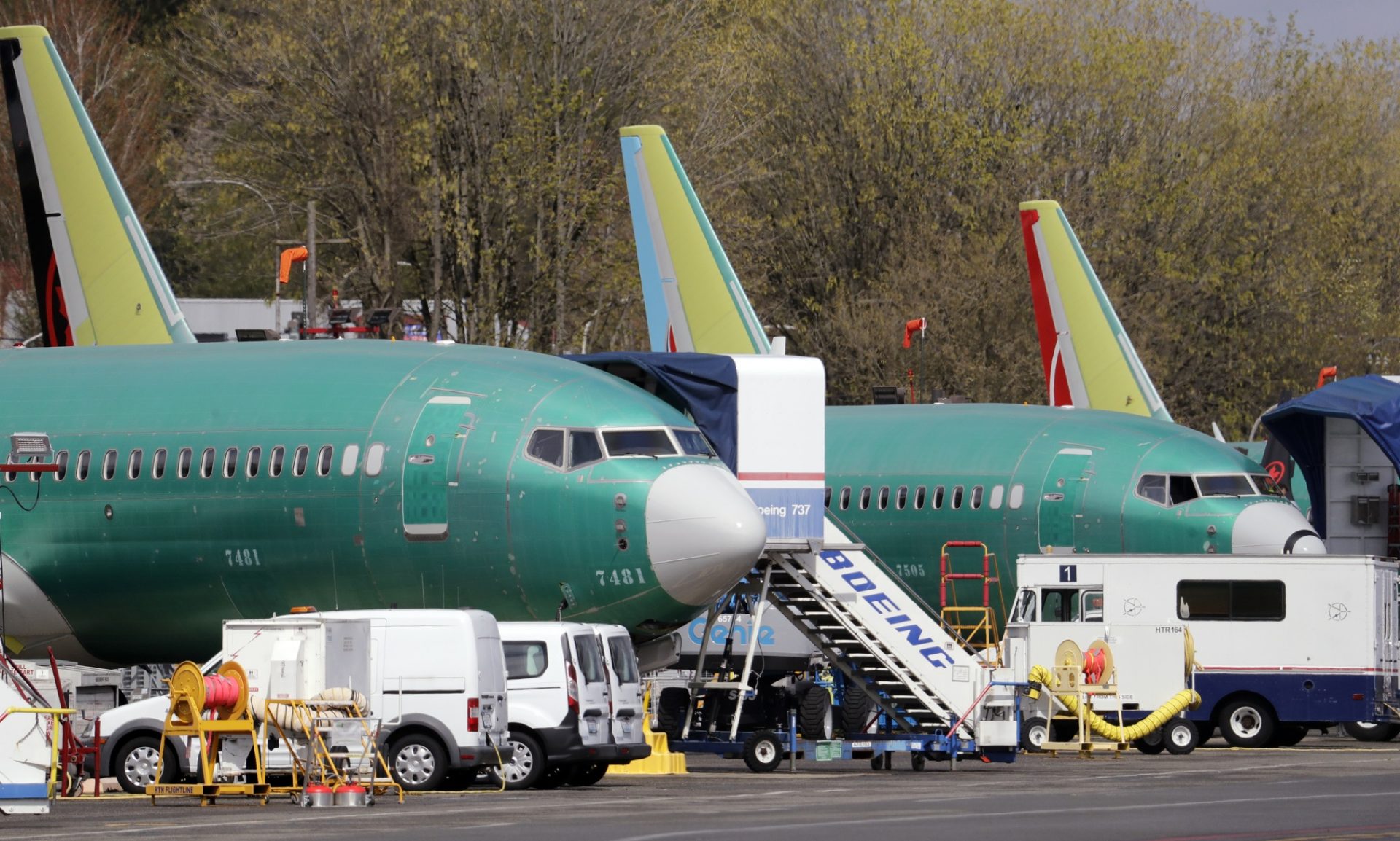 Boeing 737 Max 8 jets, built for American Airlines, left, and Air Canada are parked at the airport adjacent to a Boeing Co. production facility, Monday, April 8, 2019, in Renton, Wash. Boeing said the week before that it will cut production of its troubled 737 Max airliner in April, underscoring the growing financial risk it faces the longer that its best-selling plane remains grounded after two crashes.