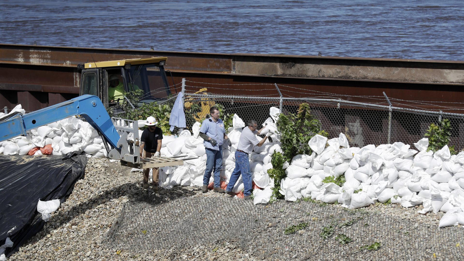 Workers build a sandbag wall near the Cedar River in Iowa in 2016. Disaster response experts say aid workers and others who could assist may not be able to travel during the pandemic.