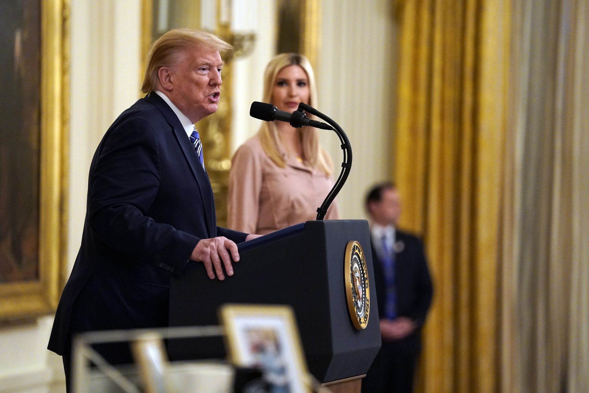 President Donald Trump speaks during an event about the Paycheck Protection Program used to support small businesses during the coronavirus outbreak, in the East Room of the White House, April 28, 2020, in Washington, as Ivanka Trump listens.