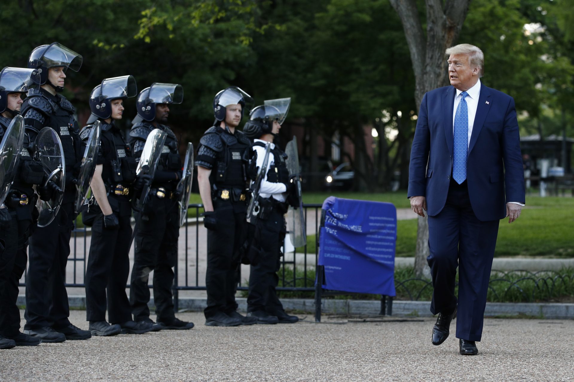 President Donald Trump walks past police in Lafayette Park after visiting outside St. John's Church across from the White House Monday, June 1, 2020, in Washington. Part of the church was set on fire during protests on Sunday night.