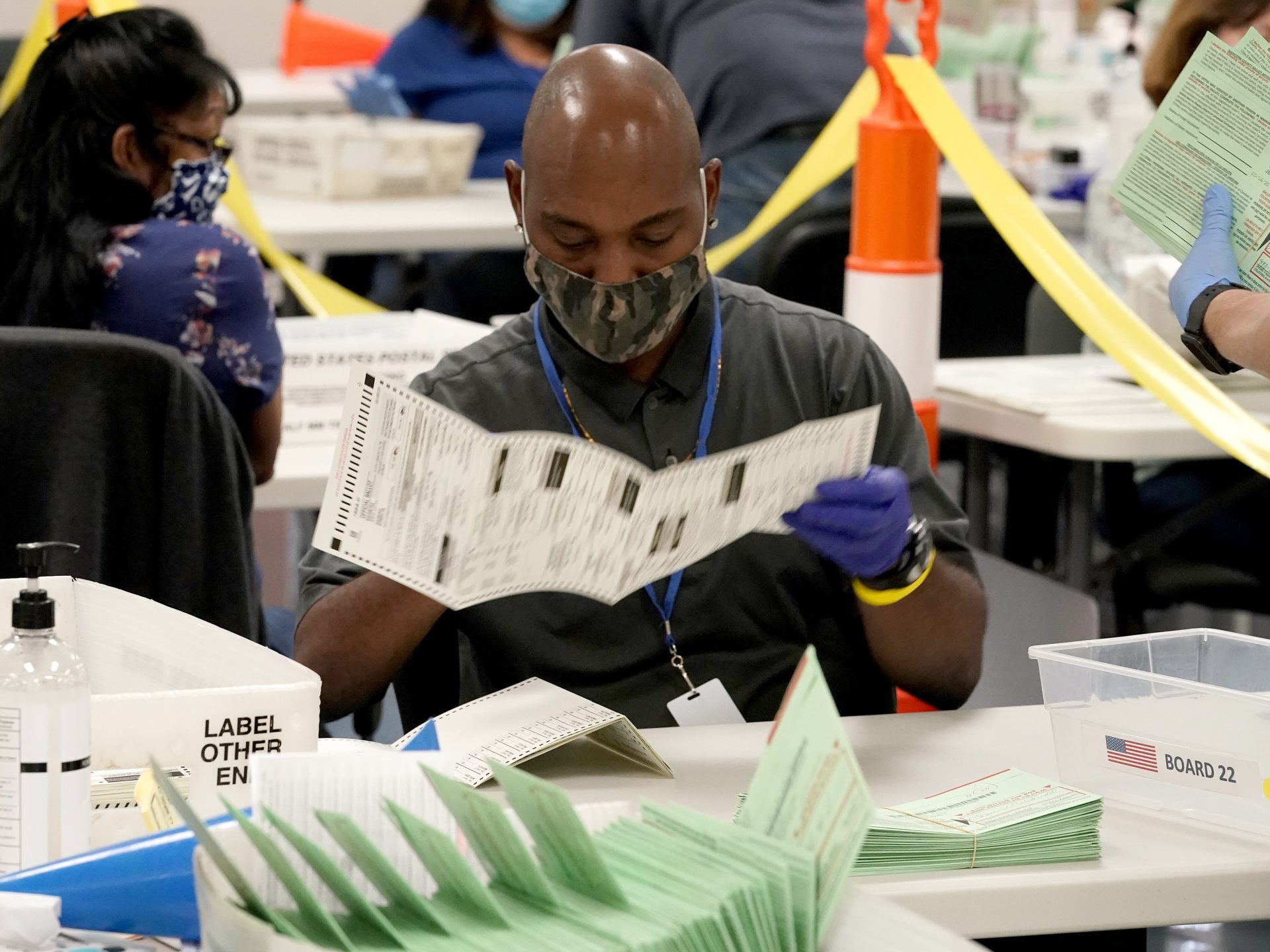 FILE - This Oct. 21, 2020, file photo shows election workers sorting ballots at the Maricopa County Recorder's Office in Phoenix.