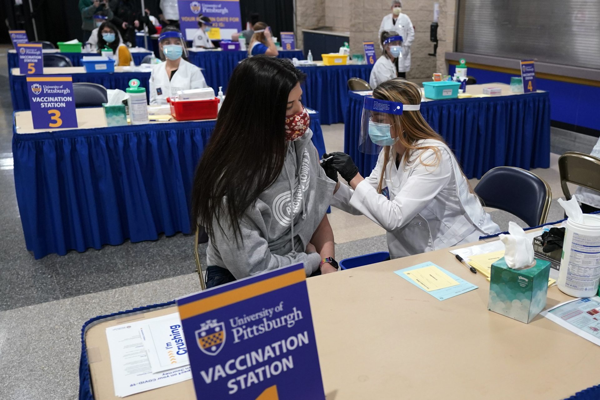 Tiffany Husak, left, a nursing student at the Community College of Allegheny County, receives her first dose of the Moderna COVID-19 Vaccine, during a vaccination clinic hosted by the University of Pittsburgh and the Allegheny County Health Department at the Petersen Events Center, in Pittsburgh, Thursday, Jan. 28, 2021.