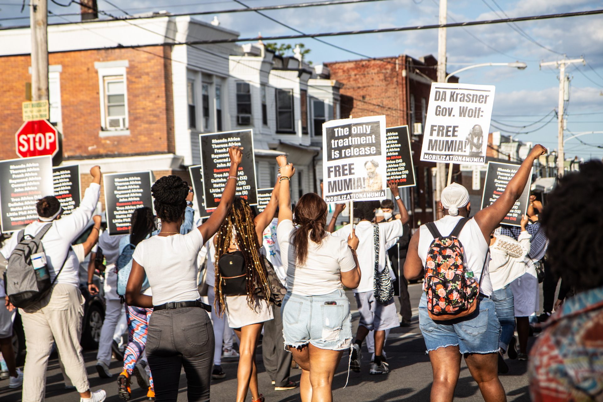 Protesters carrying signs with the names of the 11 members of the MOVE family who lost their lives on May 13, 1985, march down Pine Street in West Philadelphia in 2021.