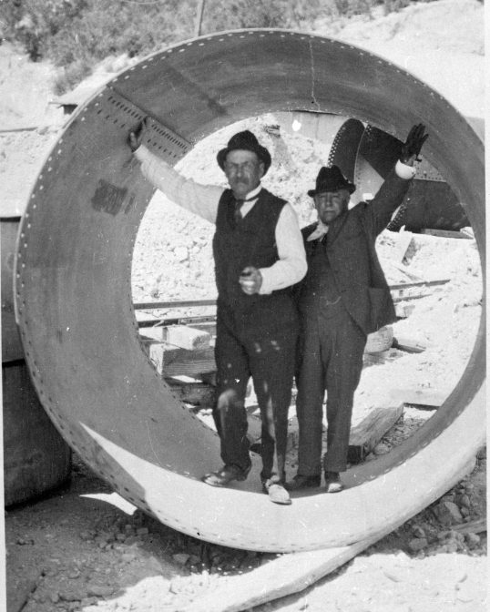 Two men standing in a cement pipe