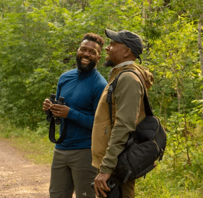 Dudley Edmonson and Baratunde Thurston walking on a trail at Hawks Ridge Nature Reserve in Duluth, MN.