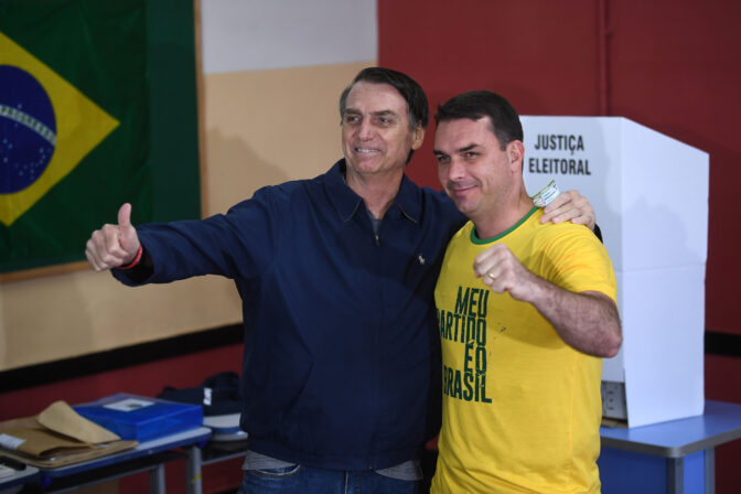 Brazil's right-wing presidential candidate for the Social Liberal Party (PSL) Jair Bolsonaro (L) poses with his son and senate candidate Flávio.