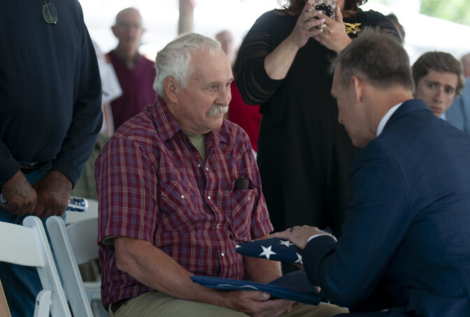 Congressman Scott Perry presents a flag to Mike Shughart at a bridge dedication for SFC Randall Shughart in Newville on May 30, 2024. (Jeremy Long - WITF)