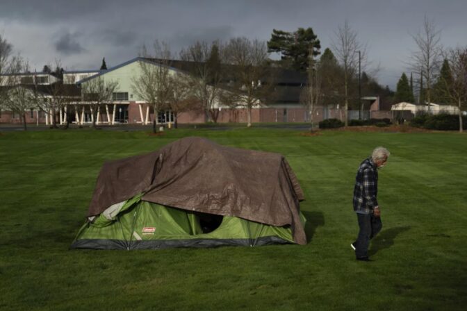 A homeless person walks near an elementary school in Grants Pass, Ore., on March 23. The rural city became the unlikely face of the nation's homelessness crisis when it asked the U.S. Supreme Court to uphold its anti-camping laws.
