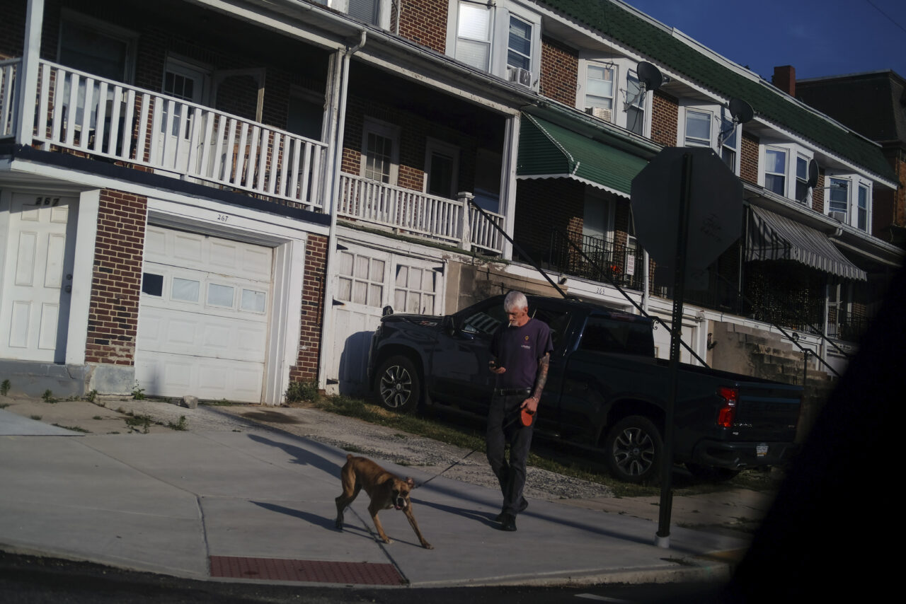 A man walks his dog in Reading, Pa., on Sunday, June 16, 2024. (AP Photo/Luis Andres Henao)