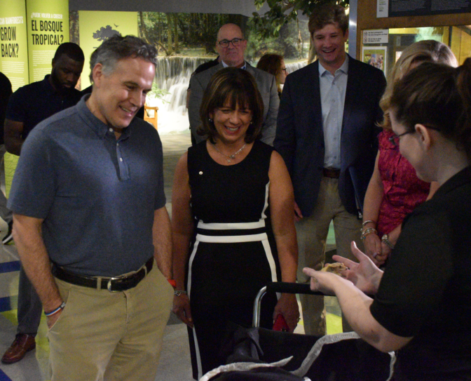 U.S. Sen. Dave McCormick and Whitaker Center CEO Mary Oliveira look at Crème Brûlée, a 13-year-old crested gecko held by Laura Bircher, lead for the Under The Canopy traveling exhibit at Harrisburg, Pa.'s Whitaker Center on July 31, 2026.